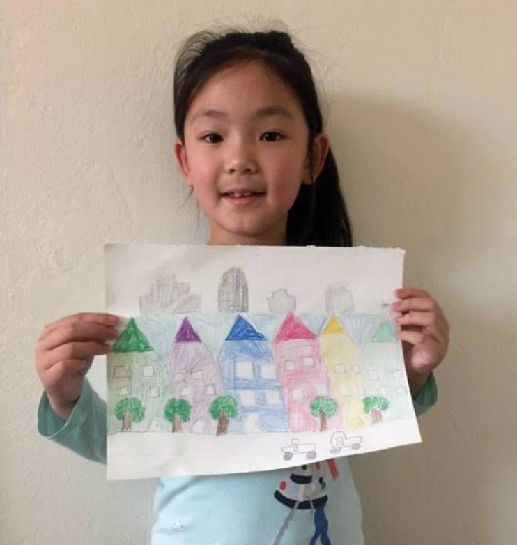 Child showing her drawing of houses.