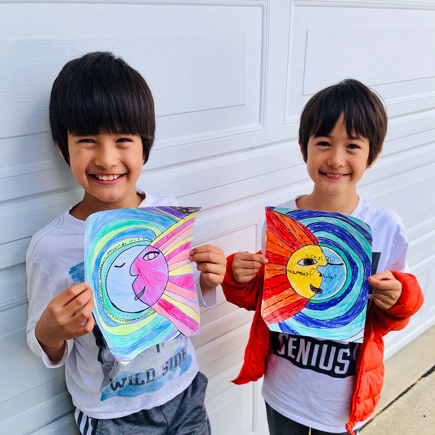 2 kids holding their artwork